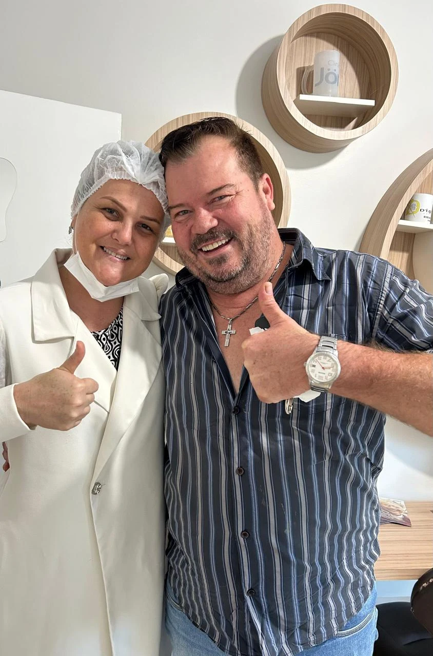 Doutora e paciente sorrindo e fazendo sinal positivo